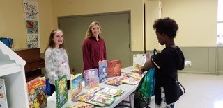 Alexis Magnano and Emily Rohan supply books for refugee students.